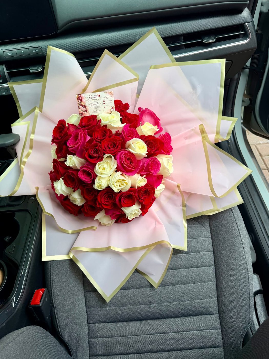 Red and white rose bouquet in pink and gold wrap
